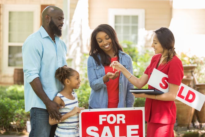 African American family posing with their Realtor after closing on their new home